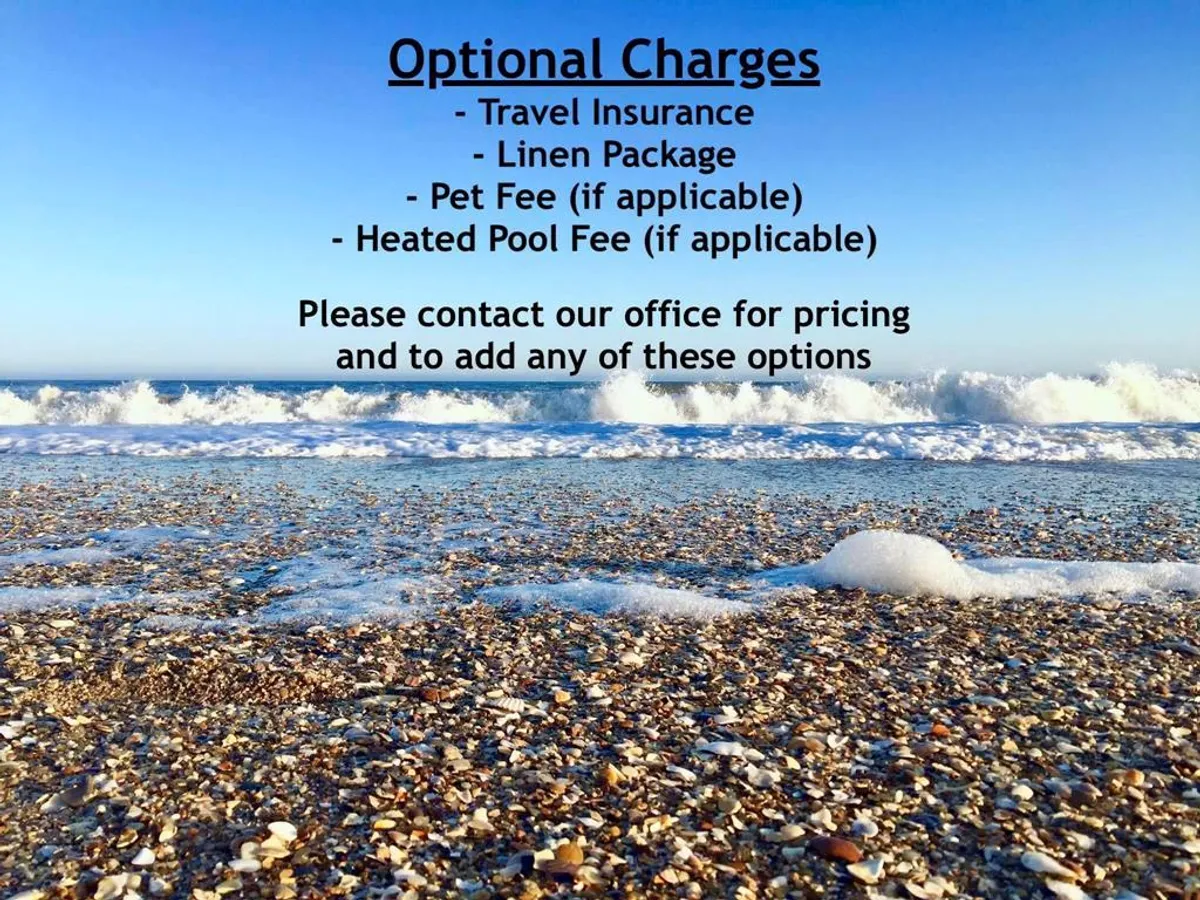 A sunlit stretch of sandy beach, gentle ocean waves, and a clear blue sky create an inviting scene. The beach looks pristine and accessible, ideal for swimming, beachcombing, or simply relaxing by the sea.